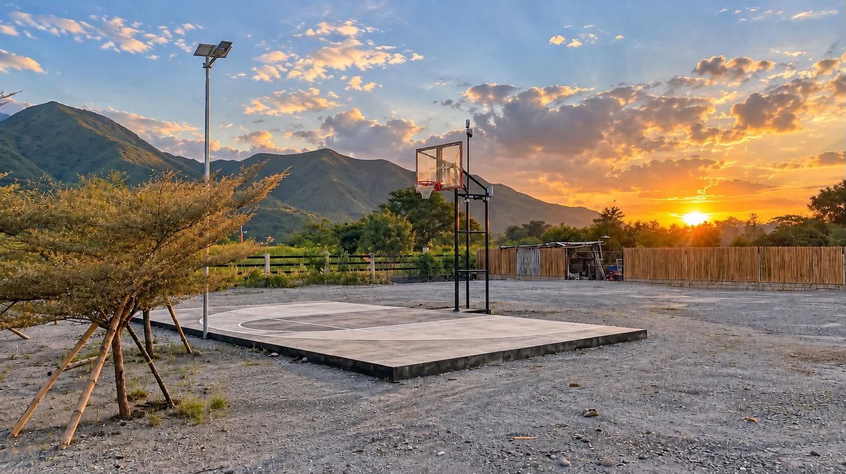 Half basketball court beneath a mountain sunset